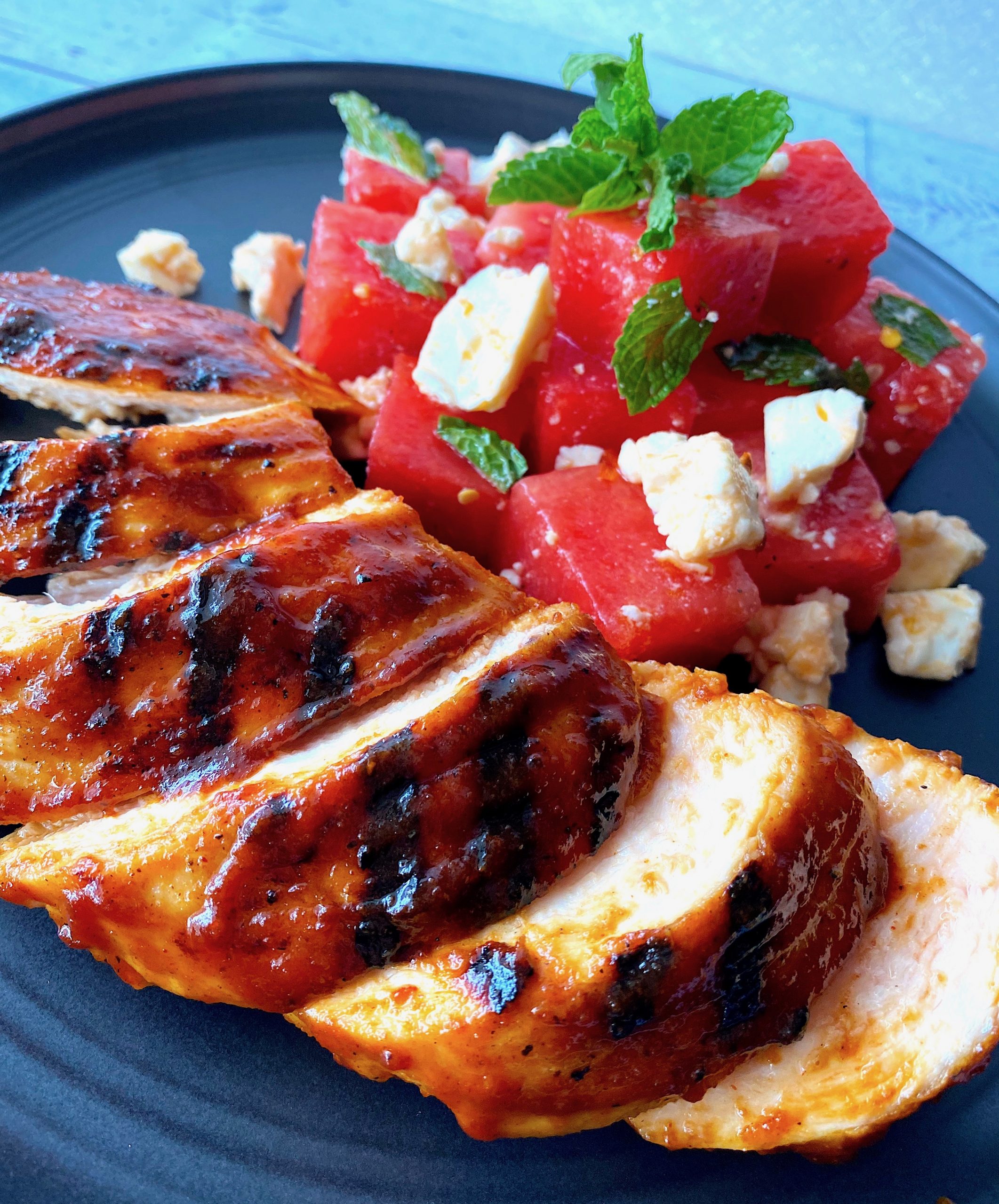 chicken breast with bbw sauce and a watermelon salad